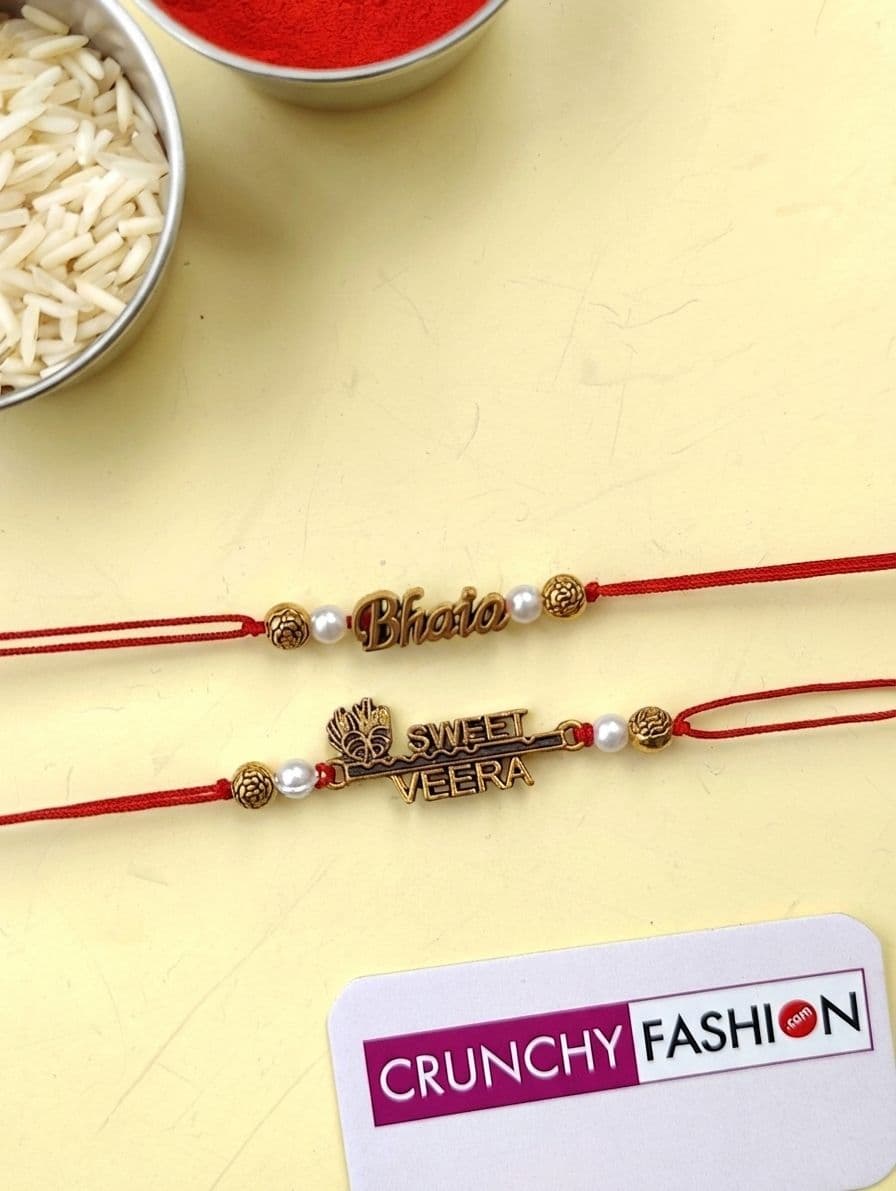 Bond of Love: Gold Alloy and Crystal Rakhi Set of 2 - Fabric Enriched